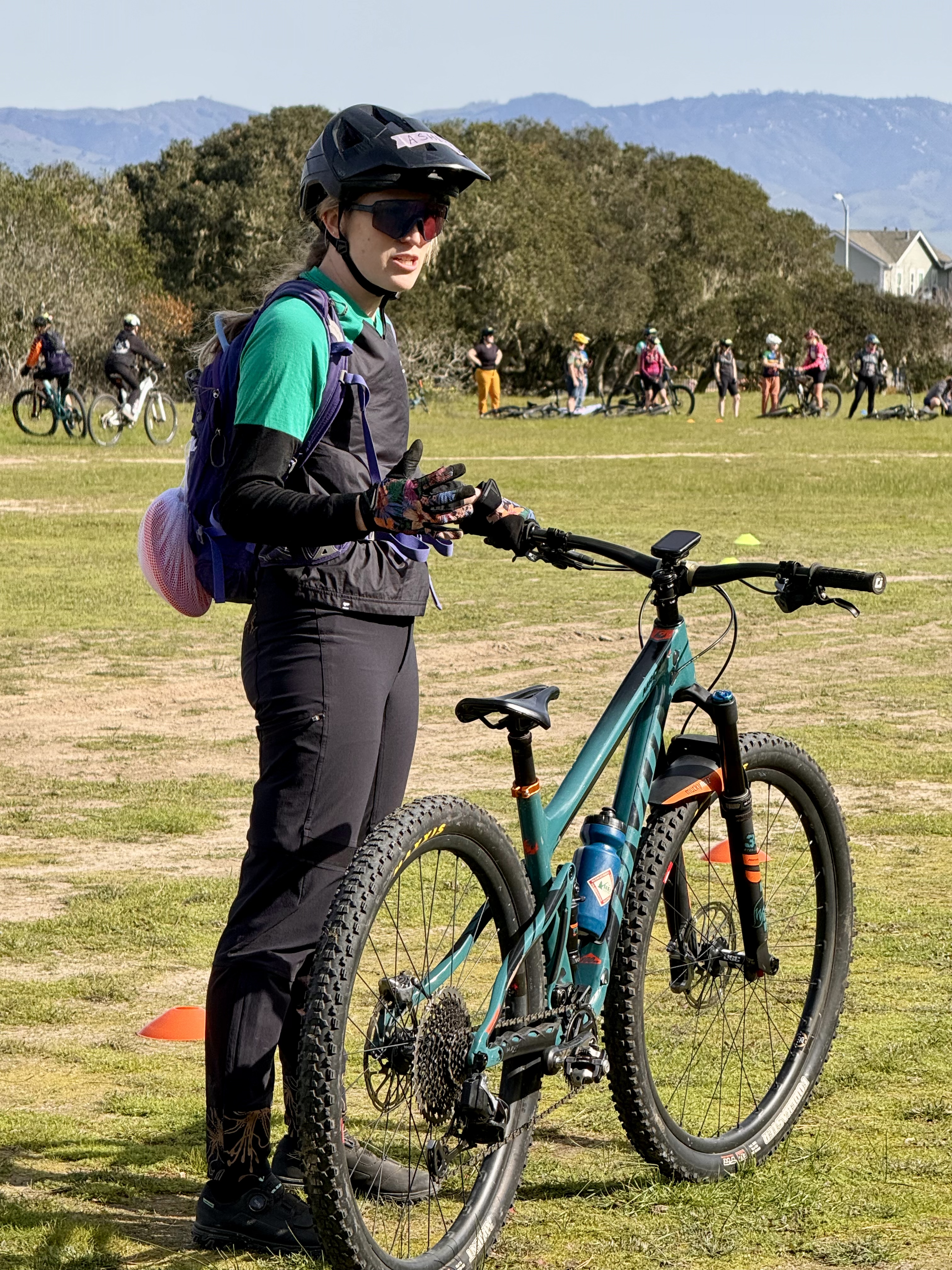 Ashlyn coaching at a clinic with riders in the background